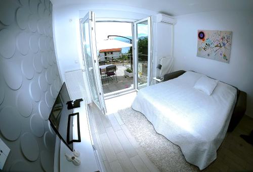 里耶卡Apartment Livingstone的卧室配有白色的床和滑动玻璃门