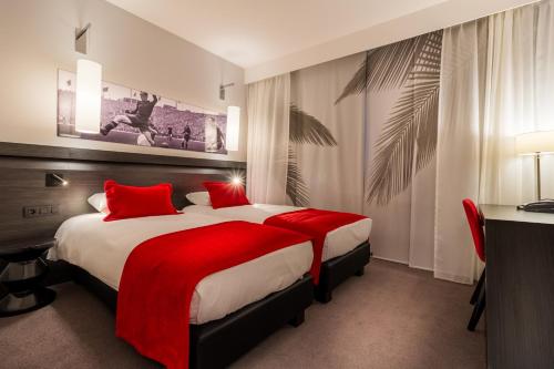 Tubize马汀红色酒店的酒店客房配有一张带红色枕头的大床