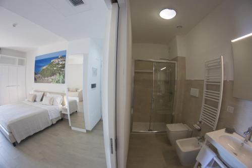 圣凯撒利亚温泉Est hotel的配有床、淋浴和盥洗盆的浴室