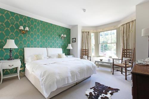 多尔金普劳旅馆的卧室配有白色的床和绿色的墙壁