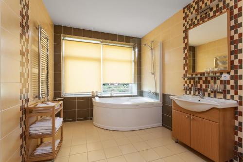德鲁斯基宁凯梅诺莉美兰公寓酒店的带浴缸、水槽和窗户的浴室