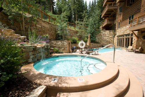 基斯通Timbers & Lone Eagle by Keystone Resort的一个带石头墙的庭院内的热水浴缸