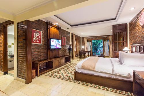 日惹杜达精品别墅酒店的一间卧室配有一张床和一台平面电视