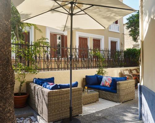 罗德镇Villa Sanyan - Adults Only的庭院设有2把藤椅和遮阳伞