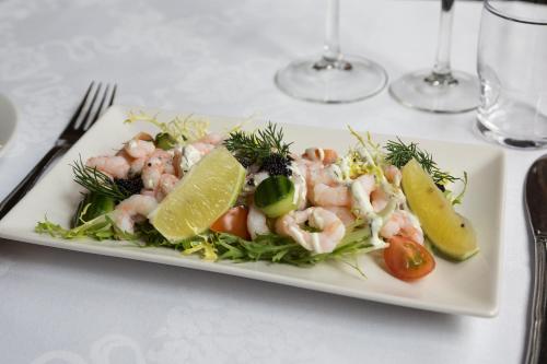 奥尔堡赫尔南凤凰酒店的桌上的虾和蔬菜白盘