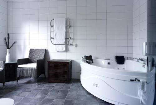 穆尔舍Hotell Björkhaga的白色的浴室设有浴缸和椅子