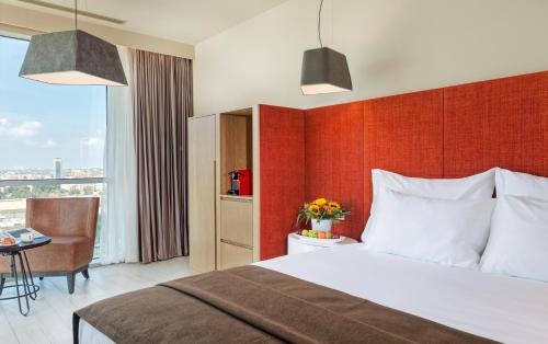 佩塔提克瓦普里马林克酒店的配有一张床、一张书桌和一扇窗户的酒店客房