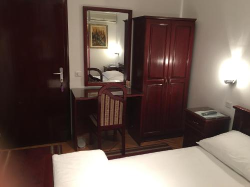 克拉列沃Vila Lux Milikic的一间卧室配有一张床、一张书桌和一面镜子