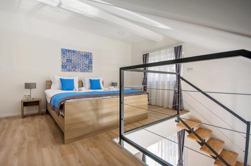 萨拉热窝享受公寓的一间卧室配有一张带蓝色枕头的床