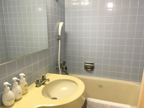 大崎市古川山丘酒店的浴室配有盥洗盆、卫生间和浴缸。
