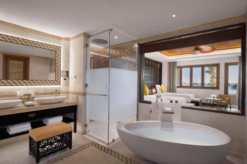 多哈多哈香蕉岛安纳塔拉度假酒店的带浴缸、两个盥洗盆和淋浴的浴室。