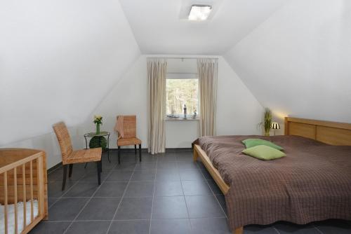 布雷格Ferienhaus Boddenblick的卧室配有一张床和一张桌子及椅子