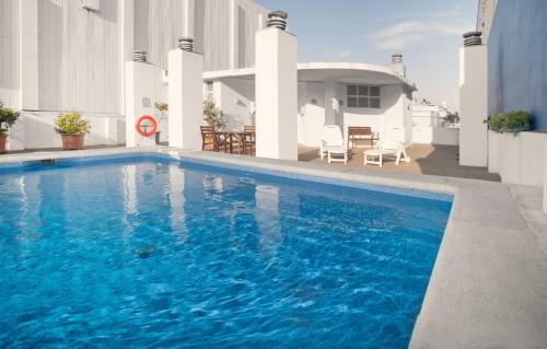 巴塞罗那费拉欧尼斯酒店的一座大蓝色游泳池,位于房子前