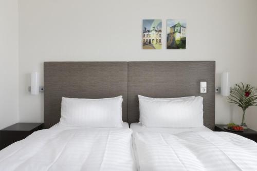 尼雪平早安尼雪平酒店的一间卧室配有两张带白色床单的床