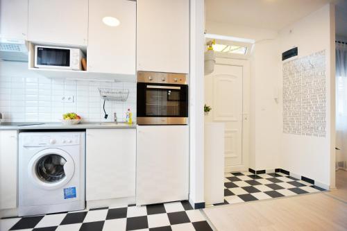 埃格尔Enjoy Apartman Eger的一间带洗衣机的厨房和 ⁇ 格地板