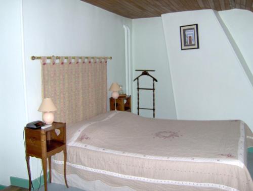 AthisAu clos des colombages的一间卧室配有一张床和一个带两盏灯的床头柜。