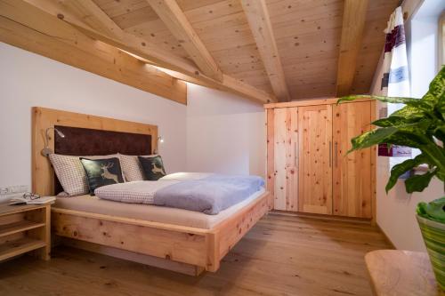 蒂罗尔州奥伯恩多夫Griesbachhof的一间带一张床的卧室,位于带木制天花板的房间内
