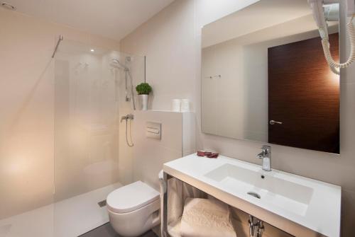 菲格拉斯邦雷腾酒店的一间带水槽、卫生间和镜子的浴室