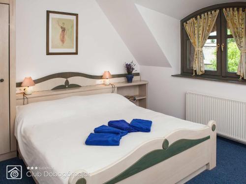 切尔塞格托毛伊多布谷马耶尔俱乐部高级酒店的一间卧室配有一张带蓝色毛巾的床