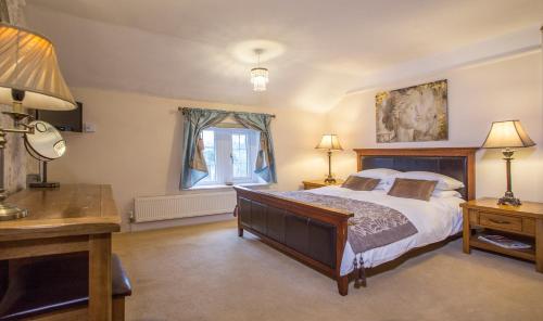 Chicklade奇科拉德古宅酒店的一间卧室配有一张床、一张书桌和一个窗户。