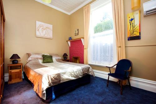 Lower Dashwood乌戈布鲁克庄园旅馆的卧室配有床、椅子和窗户。