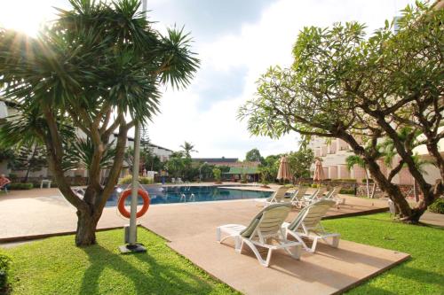 芭堤雅市中心Hotel Tropicana Pattaya的游泳池旁的一排躺椅
