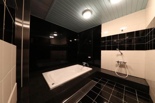 栗东Hotel Fine Shiga Ritto的带浴缸的黑白浴室
