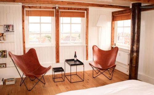 哈林亨Het Dakhuis的配有2把椅子和一张桌子的房间