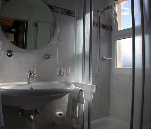 布罗克蒂维乐酒店的一间带水槽、镜子和淋浴的浴室