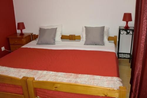 加亚新城The Yellow House的一张带红色毯子和两个枕头的床
