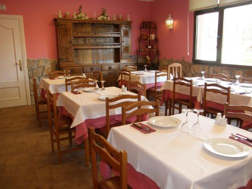 索佩拉纳果早德酒店的用餐室配有白色的桌子和木椅