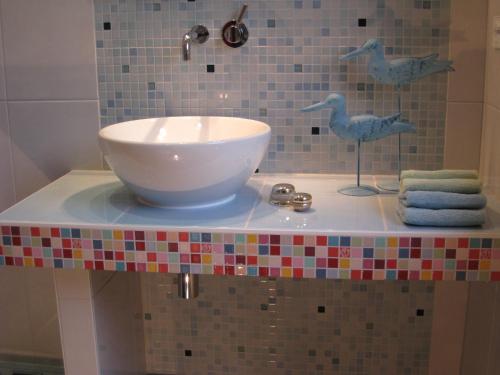 巴贝Appartement Meeresrauschen的浴室柜台设有水槽,上面有鸟儿