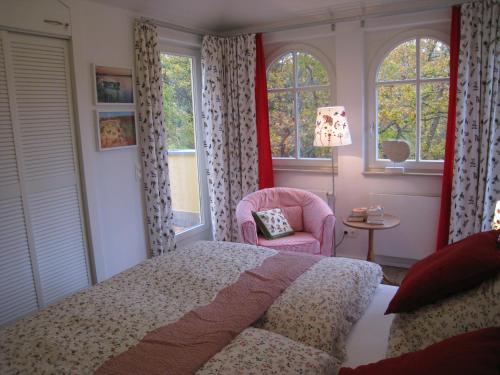巴贝Appartement Meeresrauschen的一间卧室配有一张床、一把椅子和窗户。