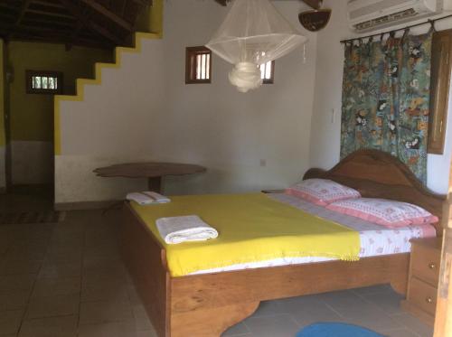 NdanganeCampement Le Cormoran的一间卧室配有一张黄色床罩的床
