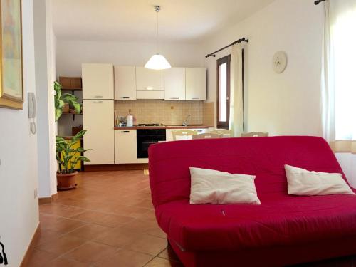 卡斯特尔萨多La Colbula的客厅里设有一张红色的沙发,配有厨房