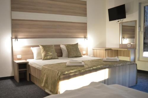 莫斯塔尔Hotel Rivero A&S的酒店客房设有两张床和电视。