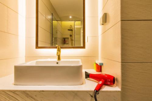 青岛青岛凯越旅馆的一间带白色水槽和红色电话的浴室