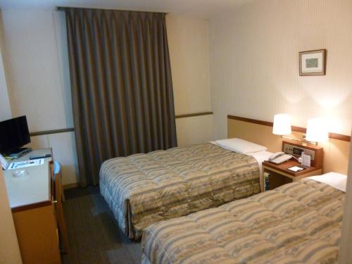 福岛福岛皇冠山经济型酒店的酒店客房设有两张床和电视。