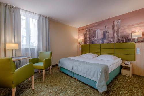 华沙雷坦酒店的酒店客房带一张床、一张桌子和椅子
