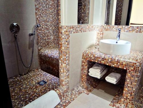 麦纳麦阿尔拉亚套房酒店的一间带水槽和淋浴的浴室