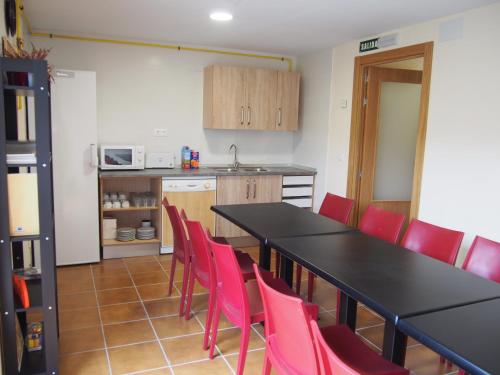 苏维里Albergue Segunda Etapa的厨房配有黑桌和红色椅子