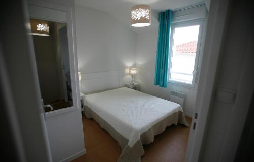 圣布莱温欧申Résidence Odalys Le Domaine de l'Océan的一间小卧室,配有床和窗户