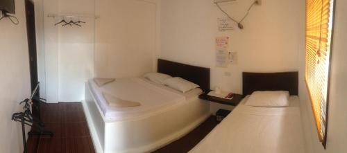 长滩岛萝拉小屋酒店的小房间设有两张床和窗户