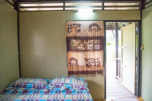 拉迈周末客简易别墅旅馆的卧室配有一张挂在墙上的床和窗帘