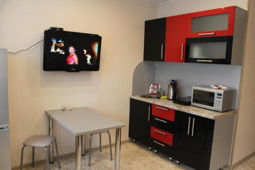 季赫温Apartments 4 Mikrorayon的一间带桌子和微波炉的小厨房