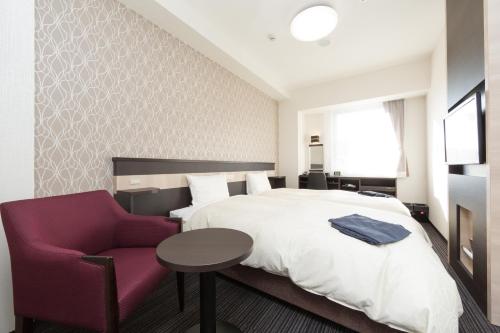 津市津駅前三交四季温泉经济型酒店的酒店客房,配有一张床和一张紫色椅子