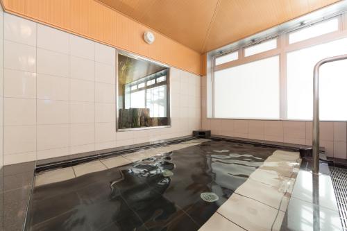 津市津駅前三交四季温泉经济型酒店的一间房间,地板上有一个水池