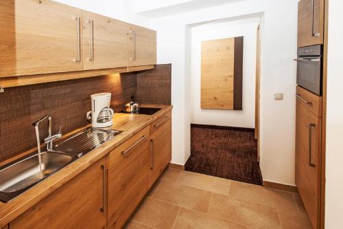 萨尔巴赫Landhaus Gappmaier的一个带木制橱柜和水槽的厨房
