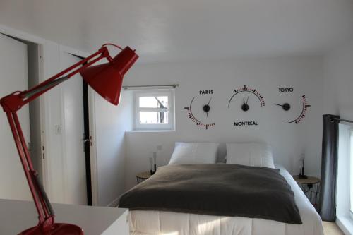 鲁昂Le Dix-Huit Studio Duplex的一间卧室配有一张床和一盏红灯