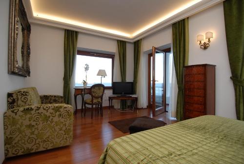 卡普里迪娃拉合族歌德尔马热酒店的一间卧室配有一张床、一把椅子和电视